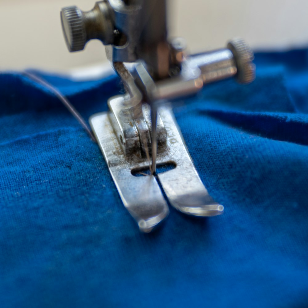 Industrial sewing machine stitching blue fabric